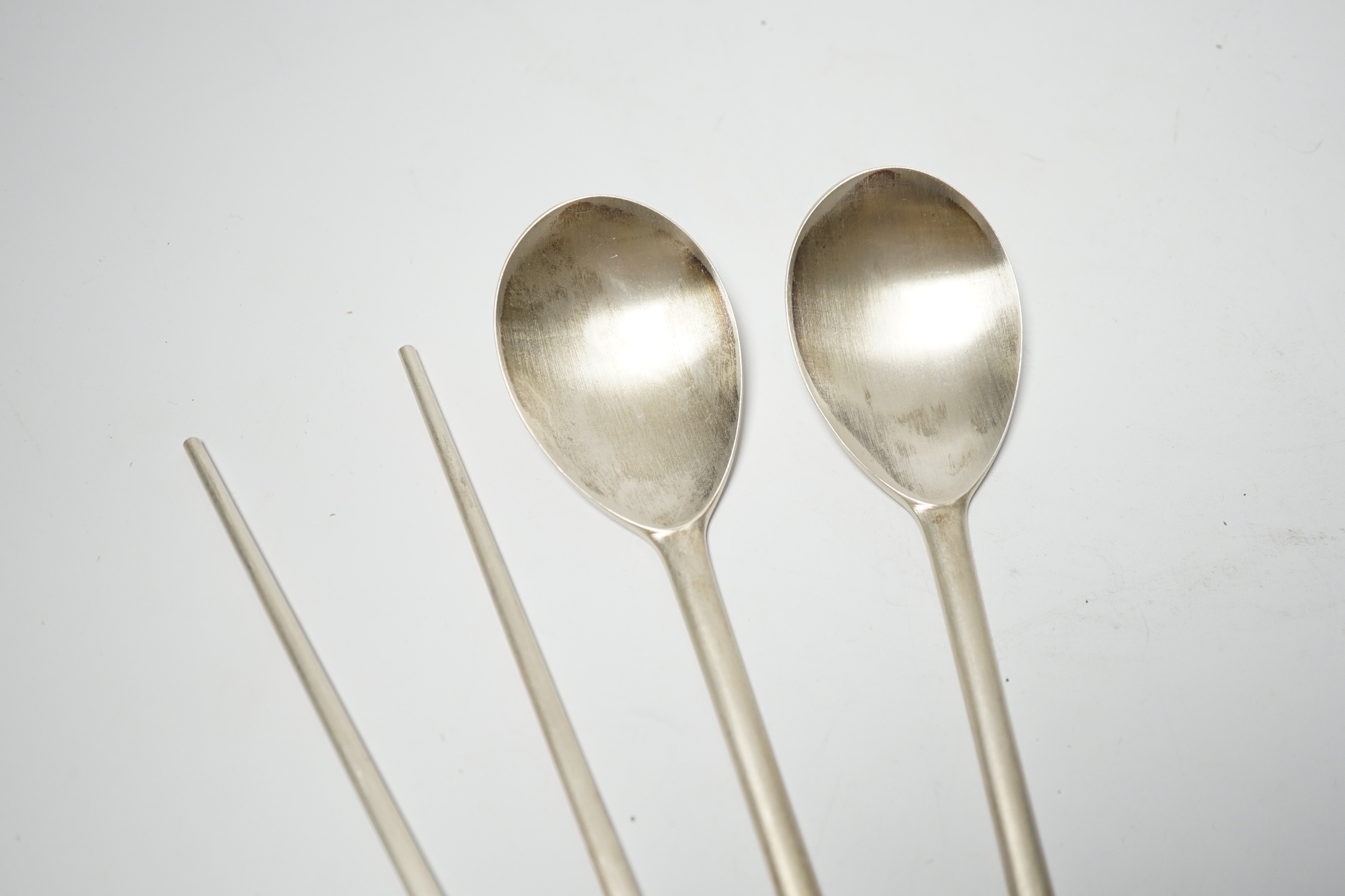 A Korean 990 standard white metal pair of chopsticks, 20cm and two matching spoons with enamelled decoration.